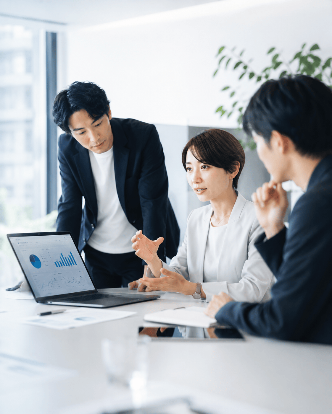 打ち合わせをする株式会社スプリードのメンバー。ノートパソコンに広告の分析ダッシュボードが表示されている。